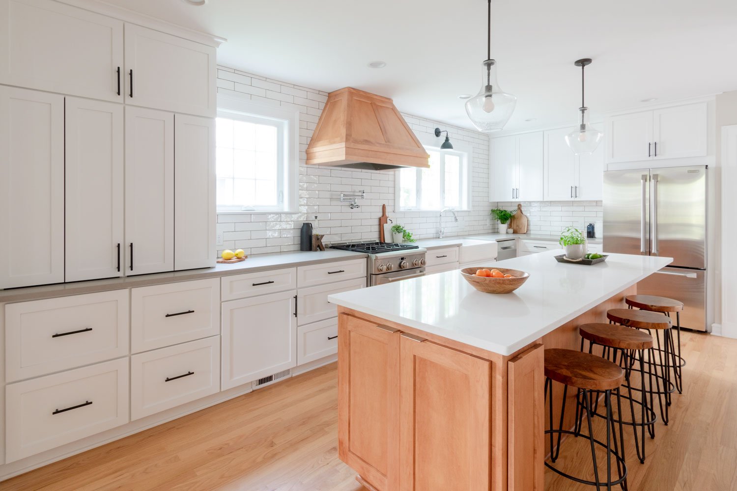 Open concept kitchen with white shaker cabinets and wood island