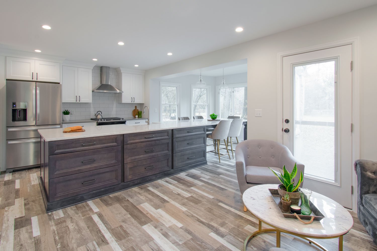 open concept kitchen with vinyl plank flooring and white quartz counters