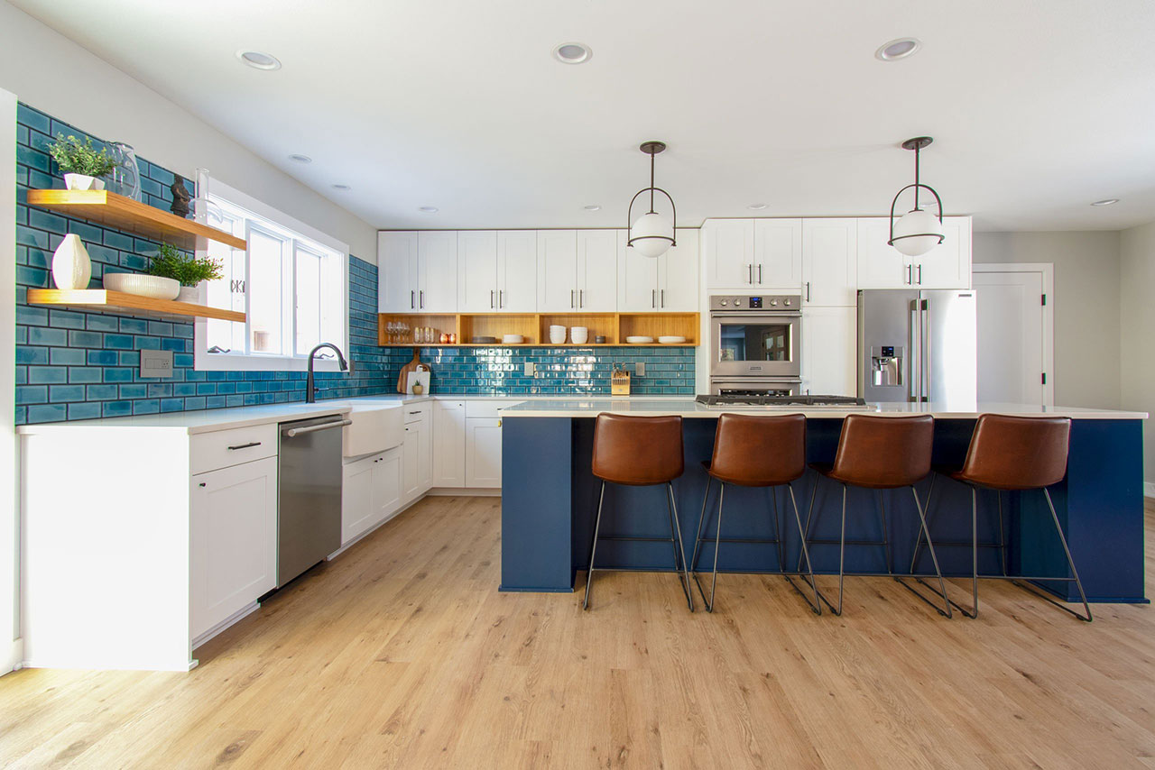 Contemporary white kitchen with blue backsplash and navy island