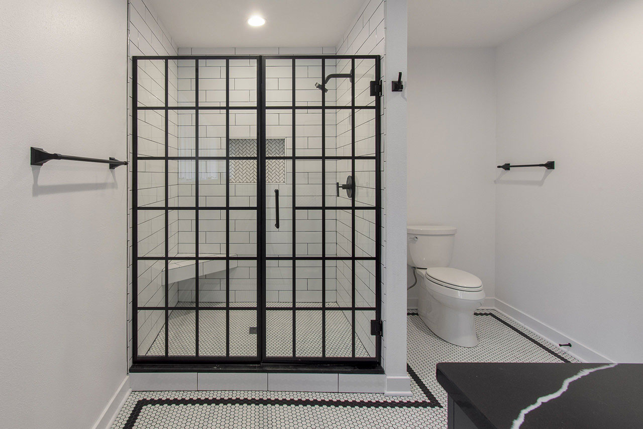 Delafield classic black and white master bathroom with subway tile glass shower door and hexagon tile floor
