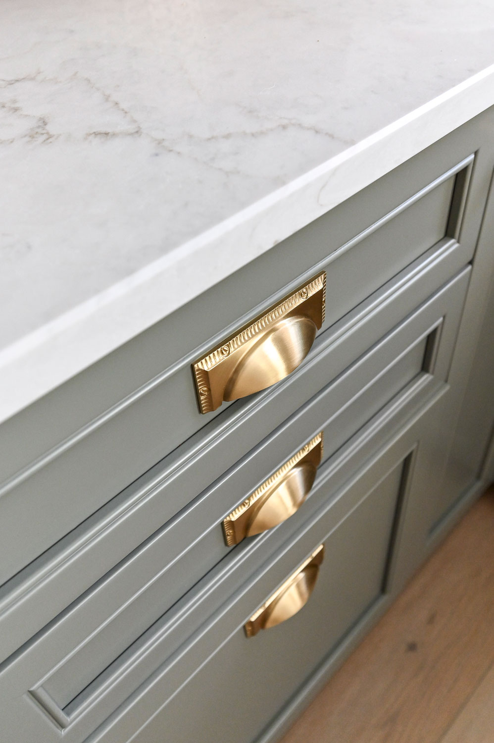gold hardware on sage green cabinets